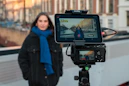 Woman recording herself with camera and tablet.