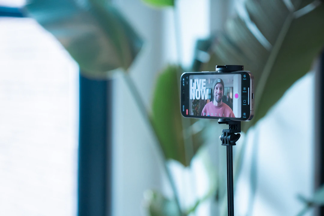 A smartphone on a tripod filming a creator, with a Live Now label on screen