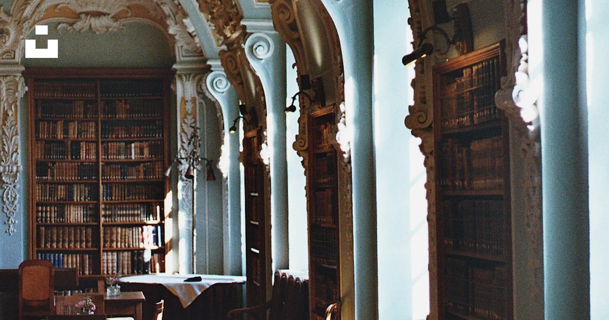 Ornate library interior with tall bookshelves and arched windows. photo ...