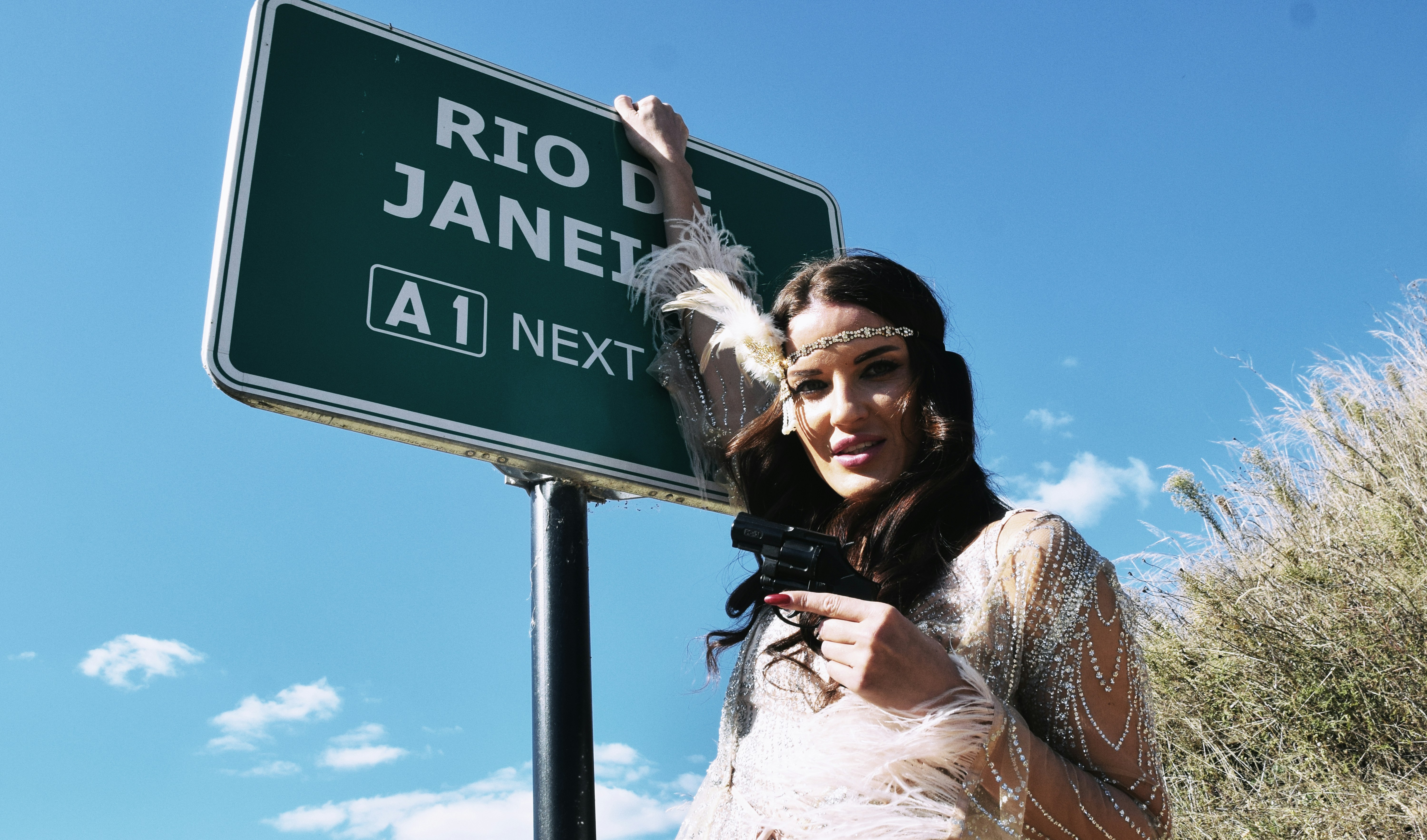 Woman posing by a rio de janeiro sign