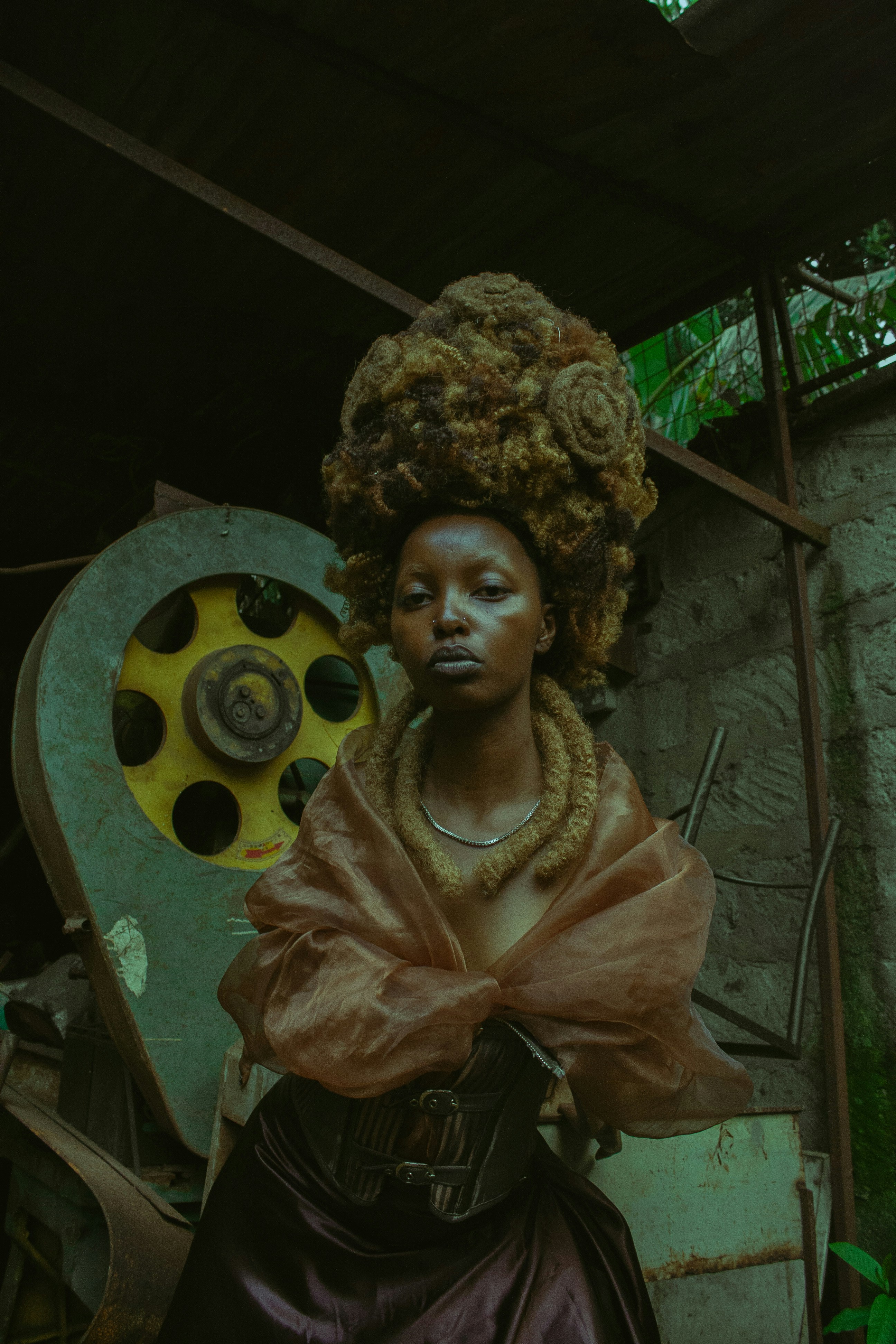 Woman with elaborate hairstyle and ornate necklace.