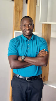 Man in blue polo shirt with arms crossed.