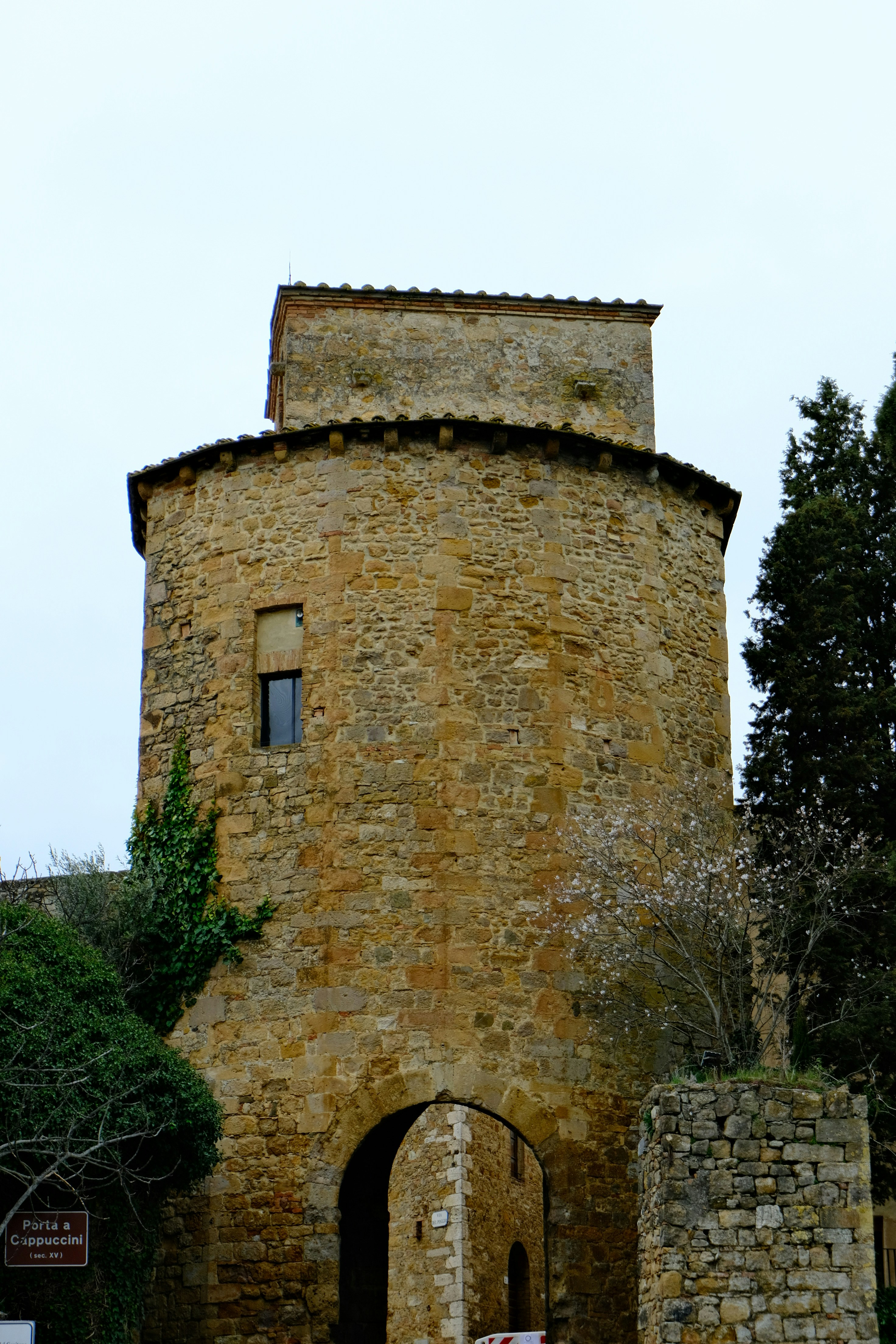 Antica torre in pietra con arco e alberi