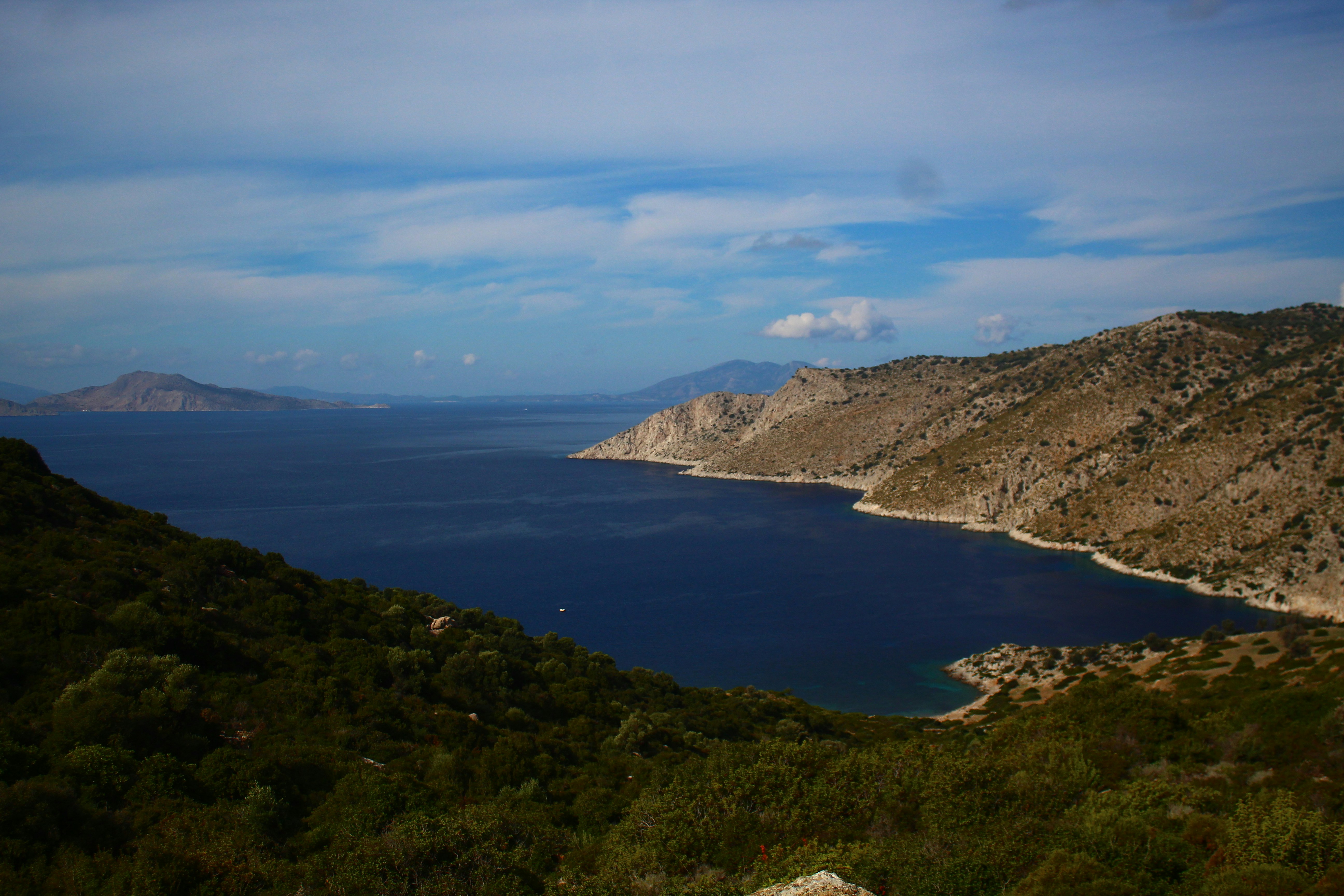 A beautiful bay with rocky shores and green hills.