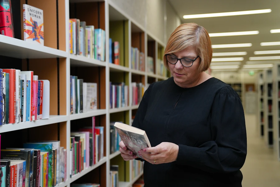 Author holding a book in a library