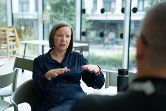 Woman gesturing while talking to person