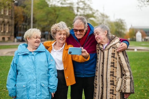 Four seniors taking a selfie outdoors