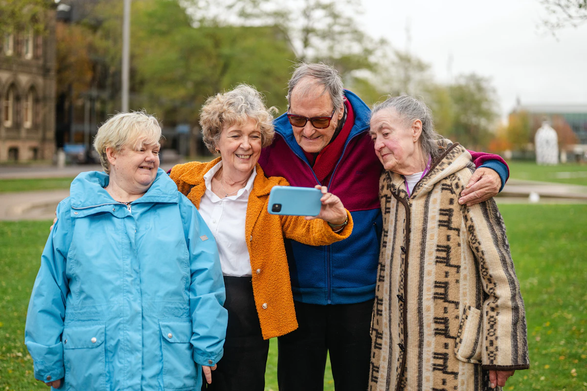 Four seniors taking a cheerful selfie outdoors