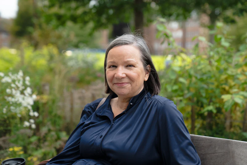 Portrait of Helen Morrison, Wellbeing and Activities Coordinator, in a garden
