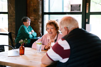 Two couples talking at a table in a cafe