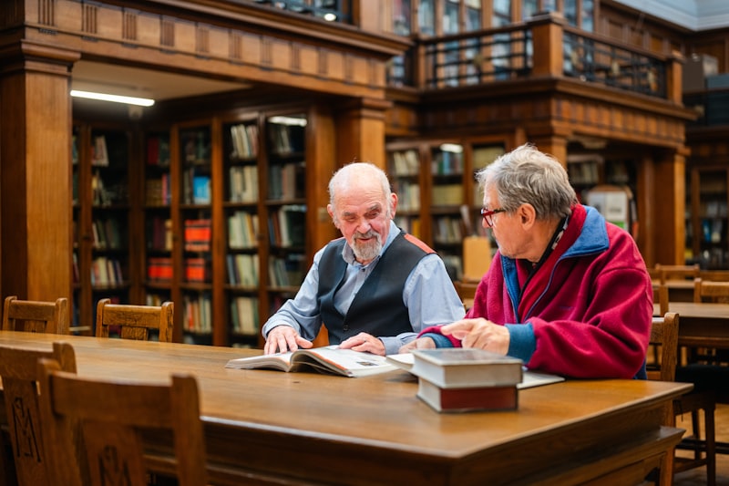 Two adult learners studying together in a library