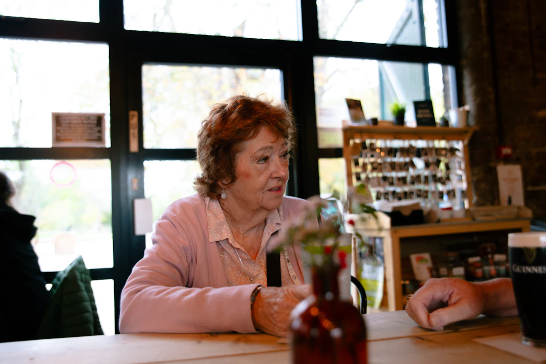 An older woman at a bright dining table, where malnutrition in nursing homes often first becomes visible