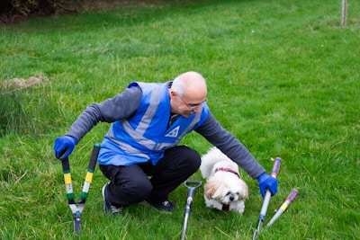 Gardener with tools and small dog on grass
