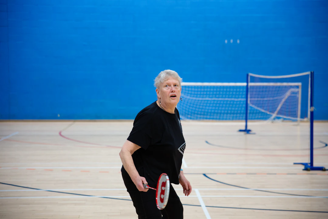 Active senior woman playing badminton