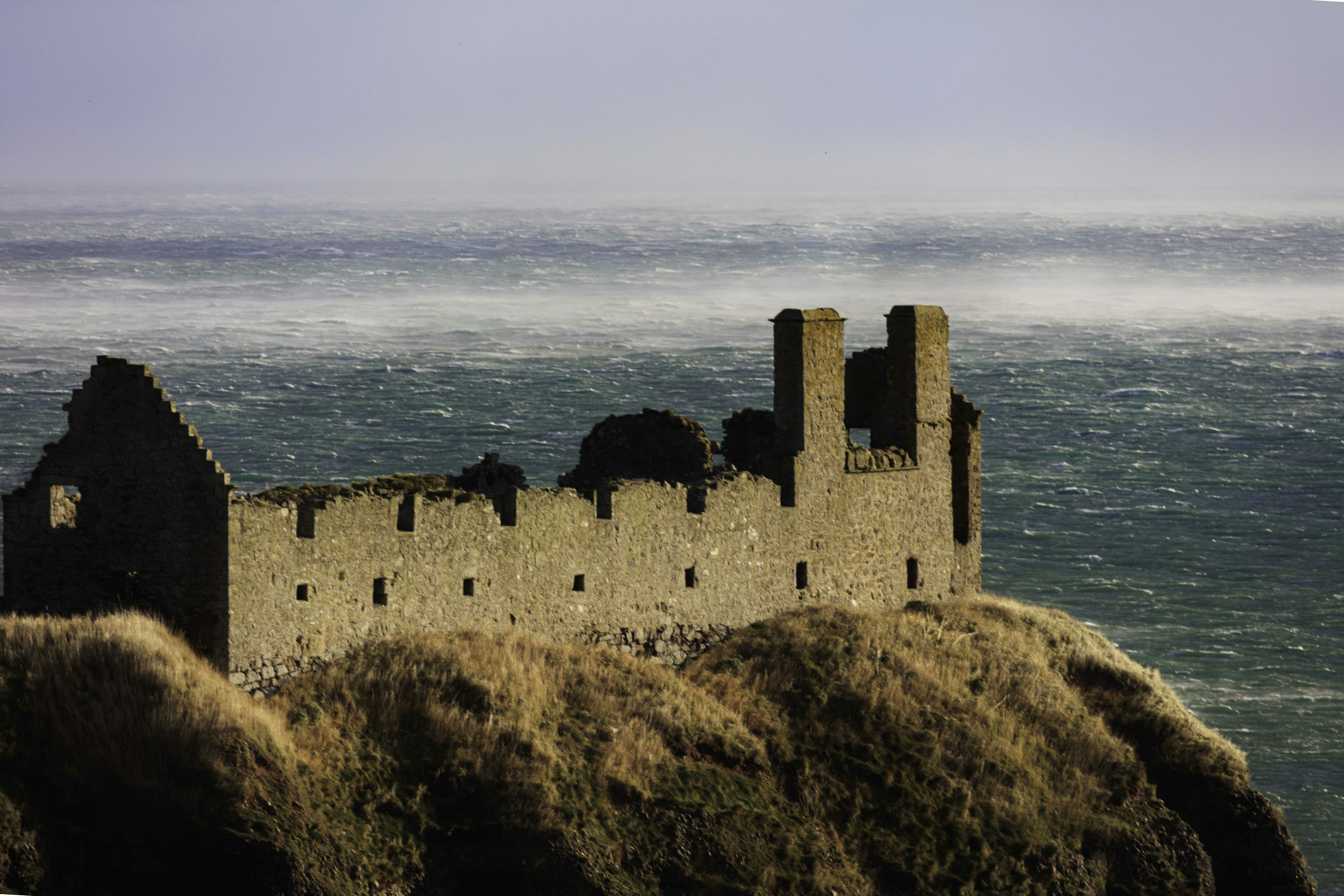 Ancient stone ruins on a cliff overlooking the sea.
