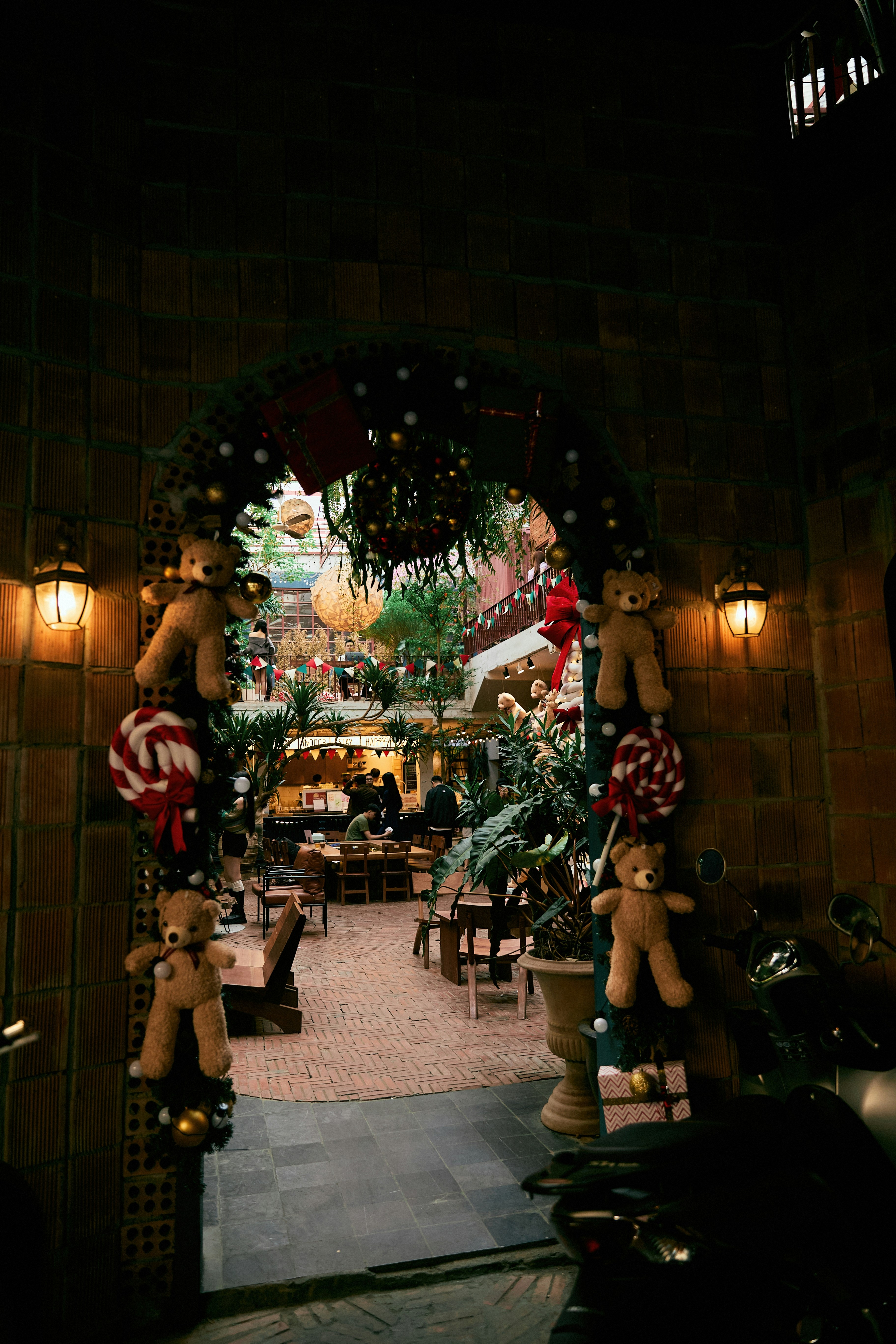 Christmas decorations adorn an arched doorway with teddy bears.