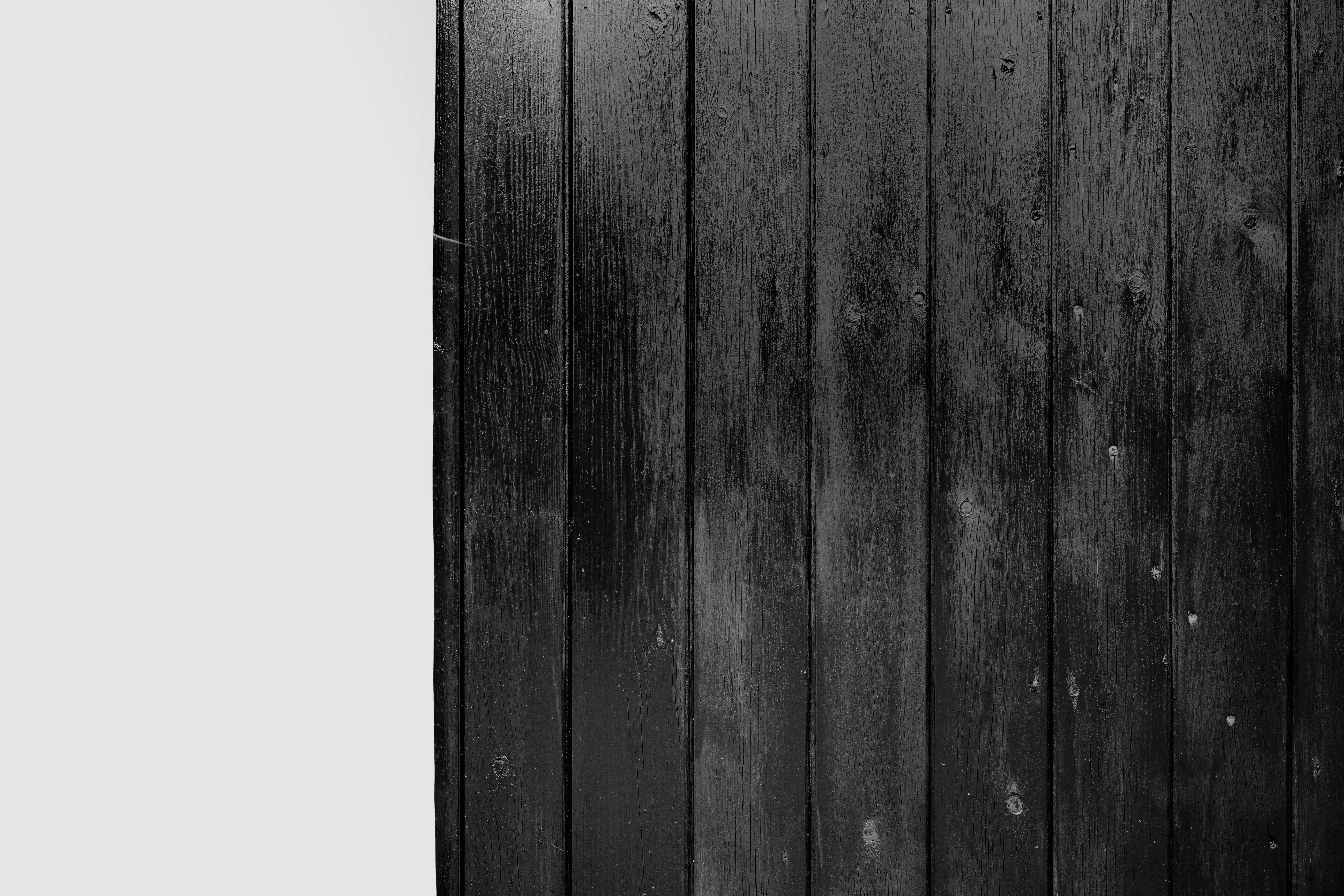 Dark wooden planks beside a white wall.