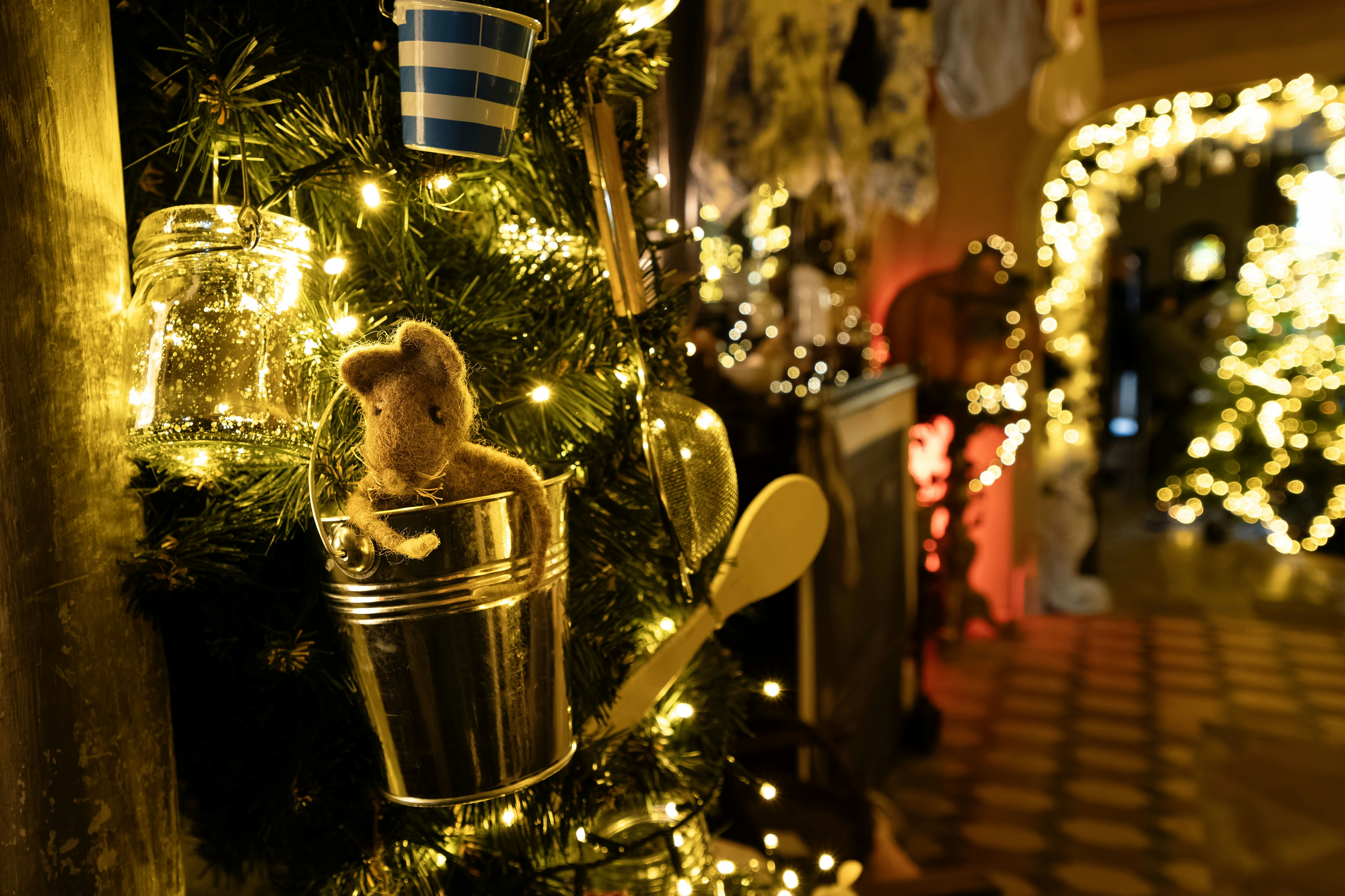 Christmas tree decorated with jar, lights, and toy.