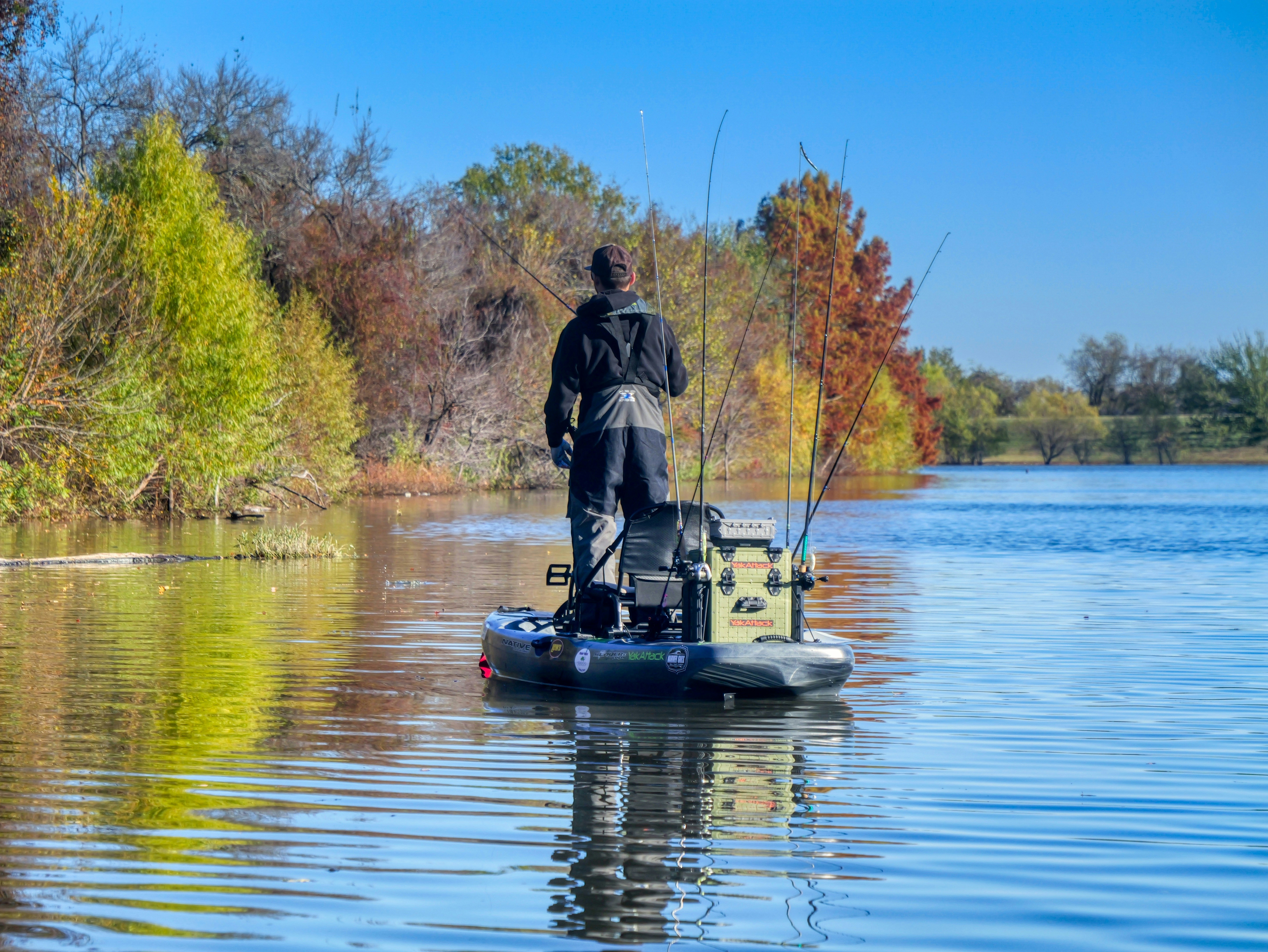 Man fishing from a kayak on a lake.