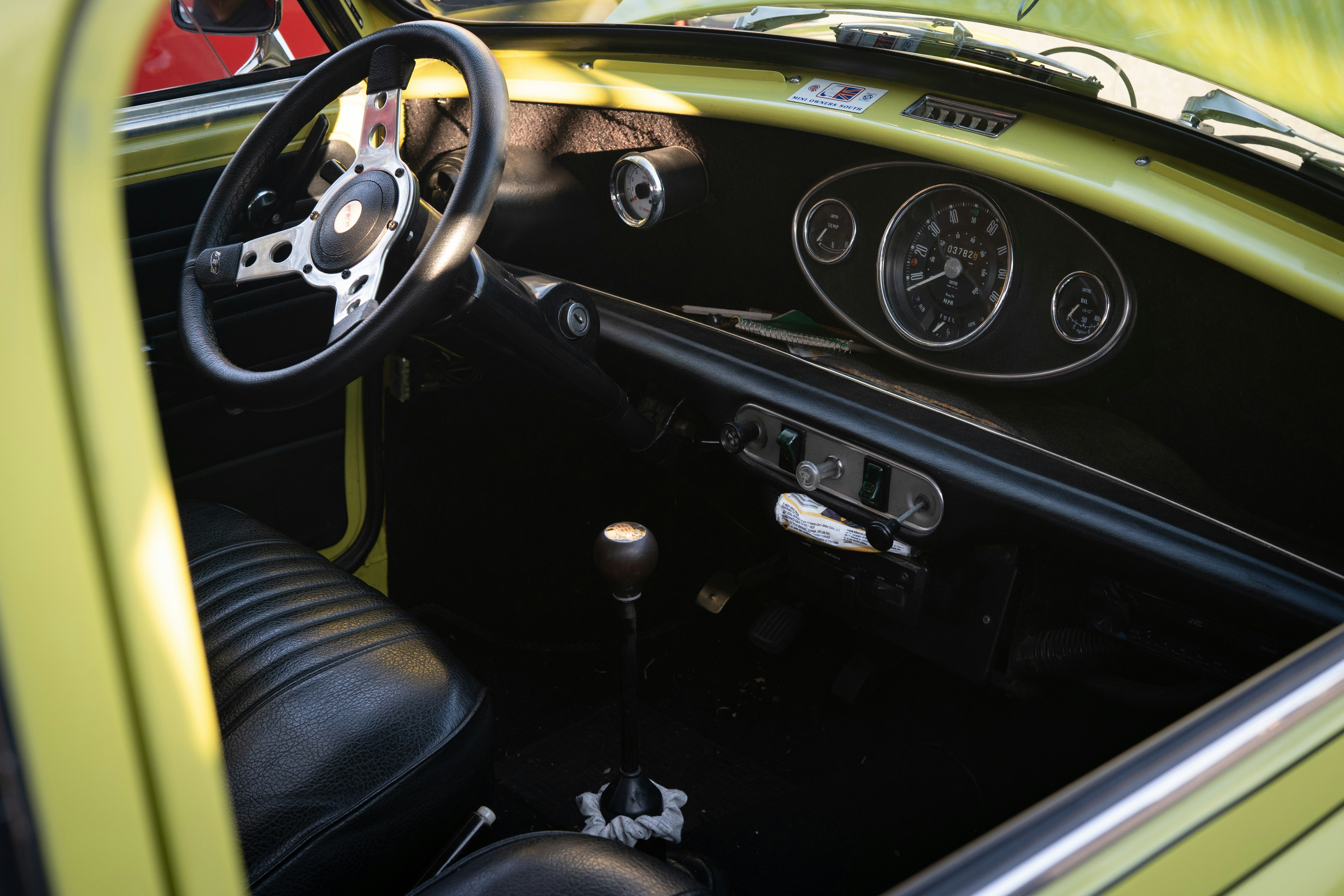 Interior of a vintage yellow car with dashboard.