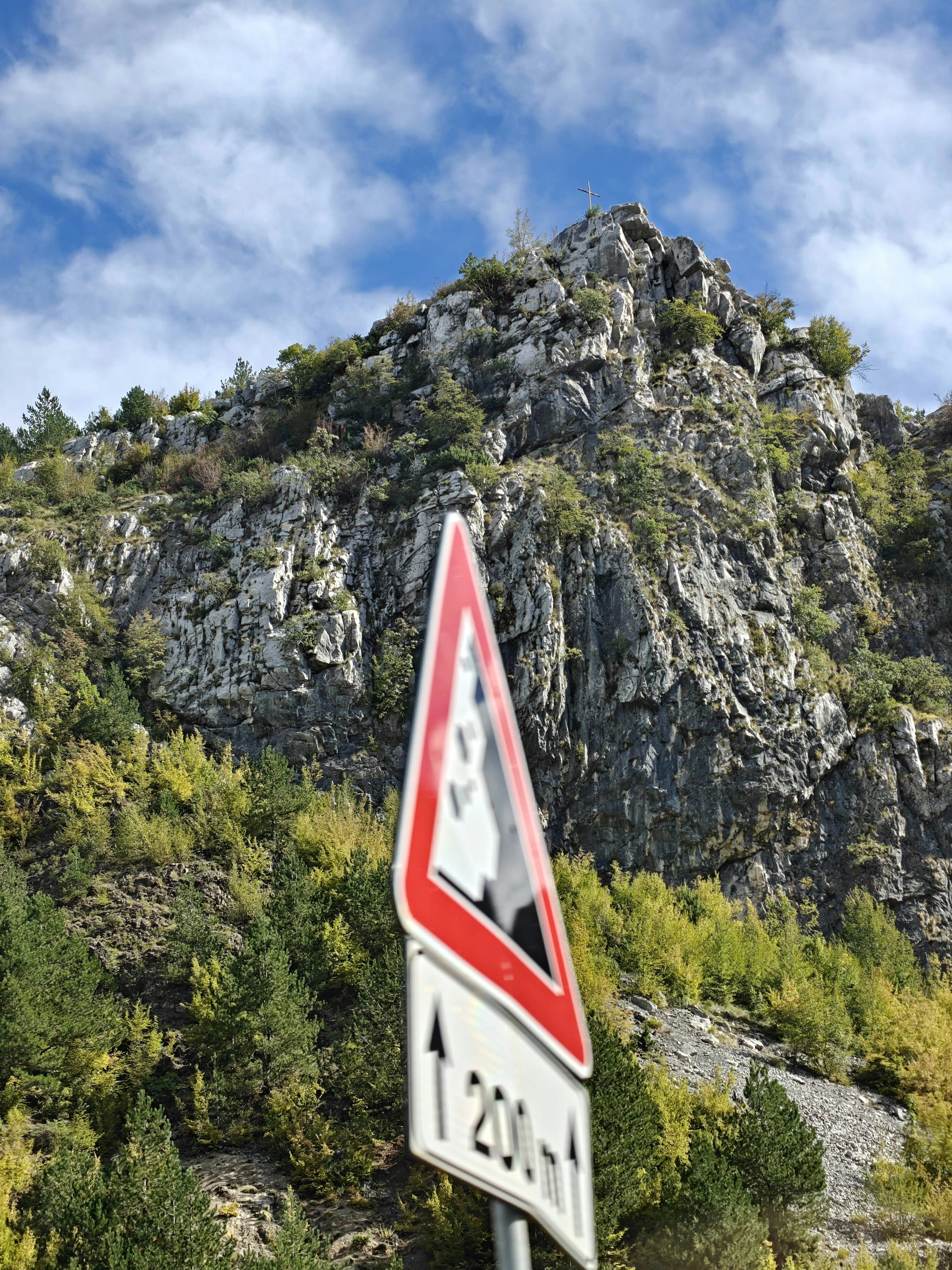 Road sign with falling rocks warning and mountain background photo ...