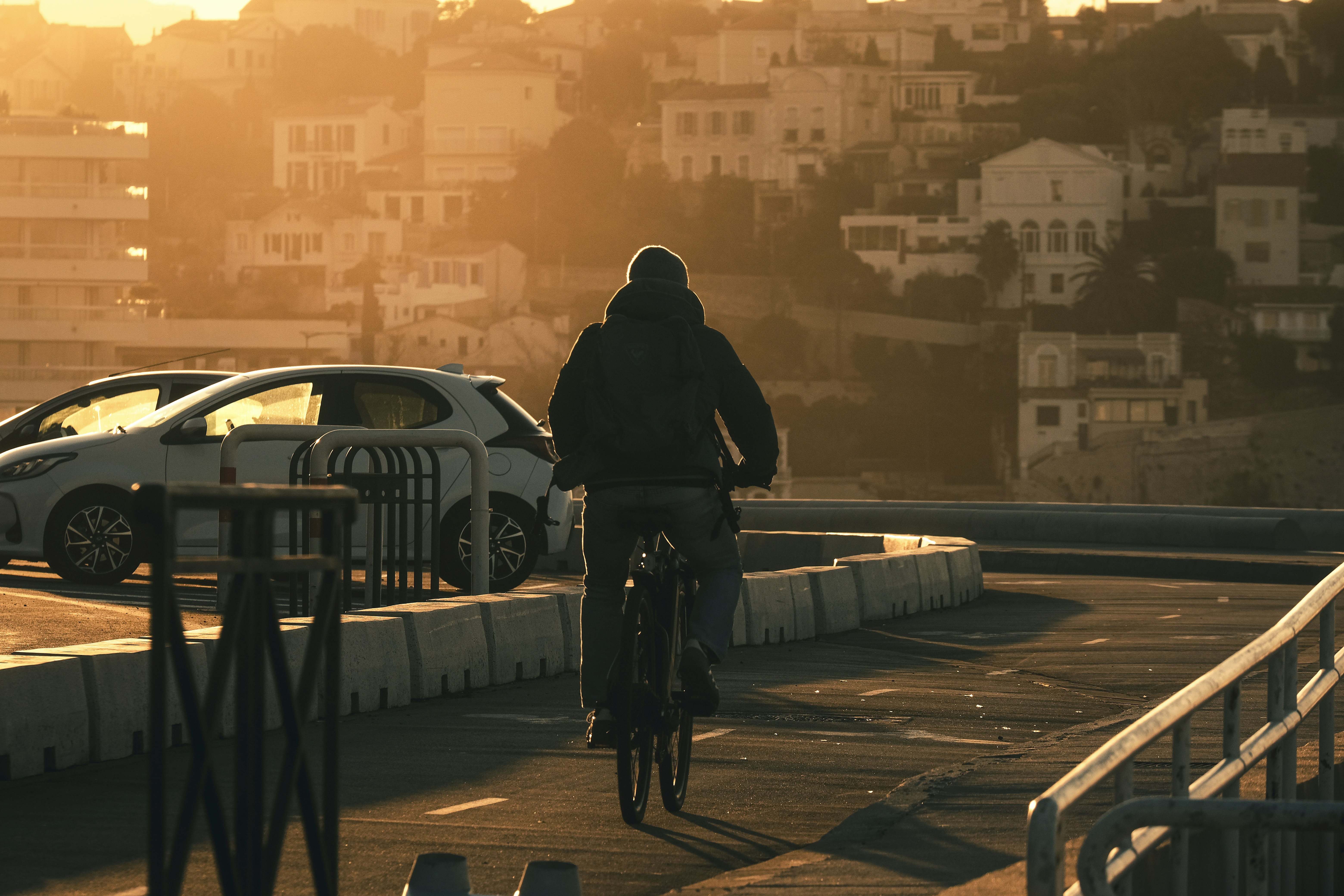 Person cycling on a road at sunset.