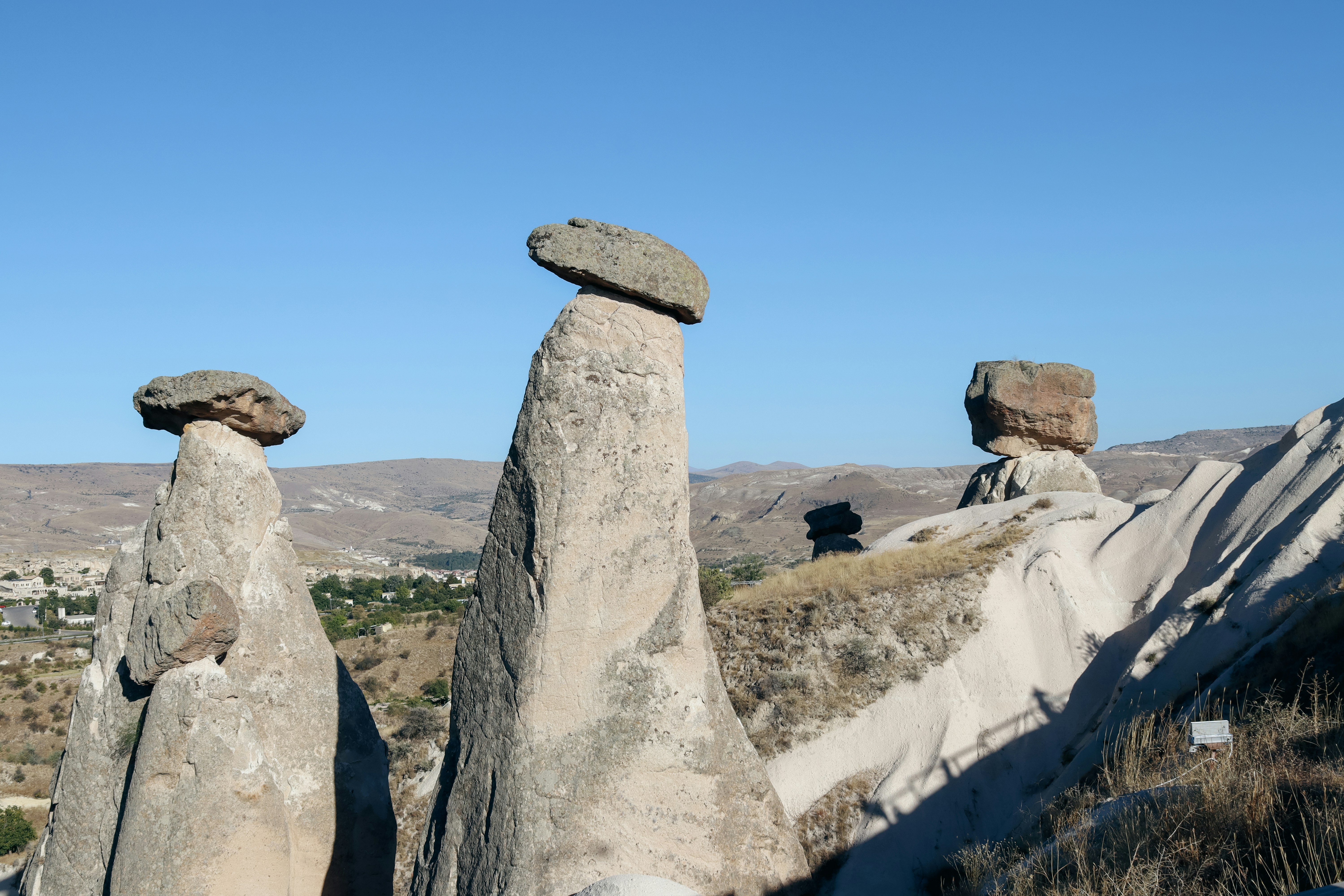 Three unique rock formations under a clear blue sky.