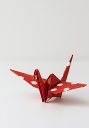 Red origami crane with white polka dots
