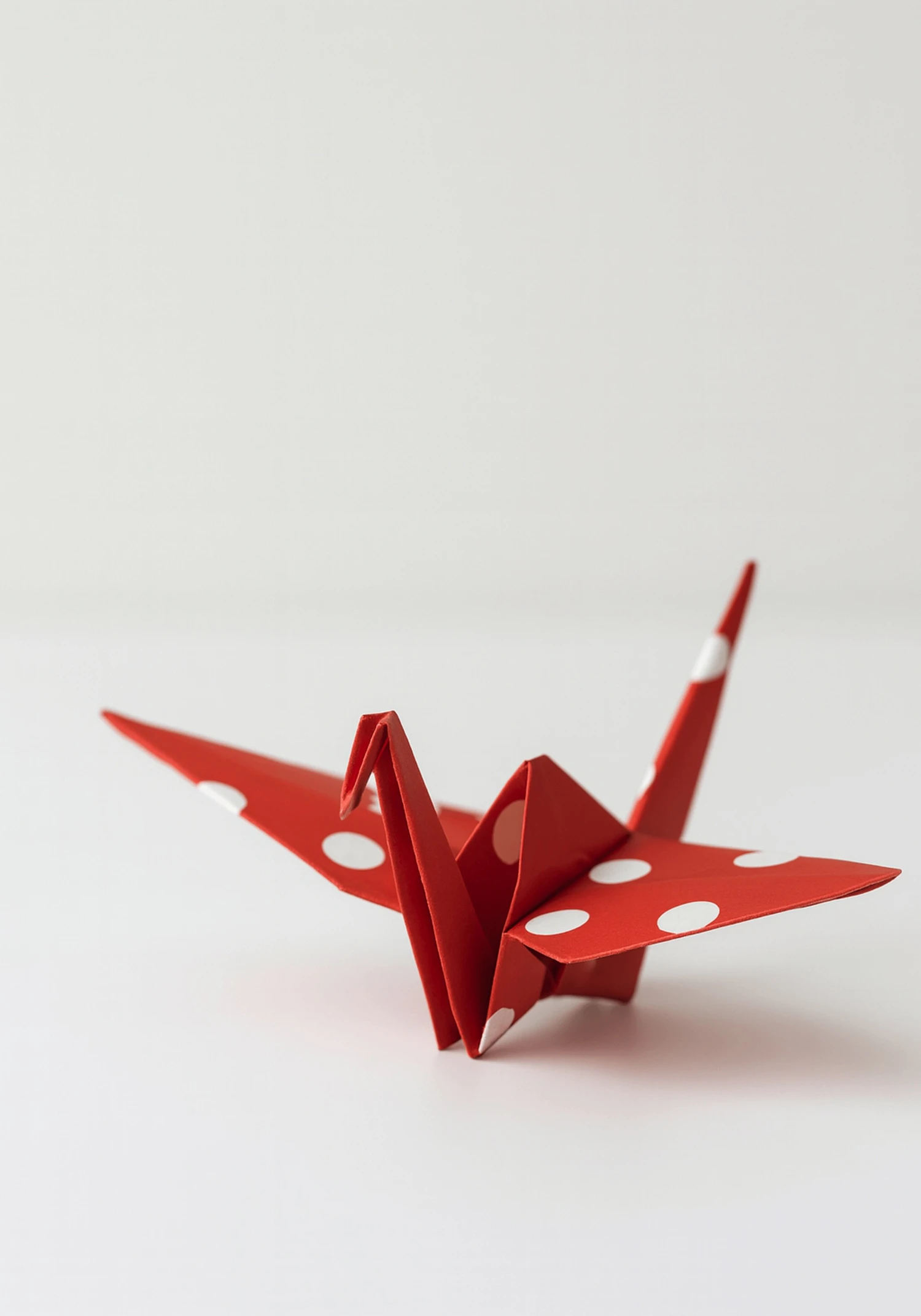 A red crane folded from white-dotted chiyogami