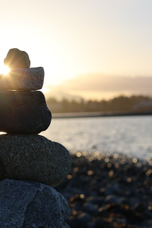 Stacked rocks on a beach at sunset