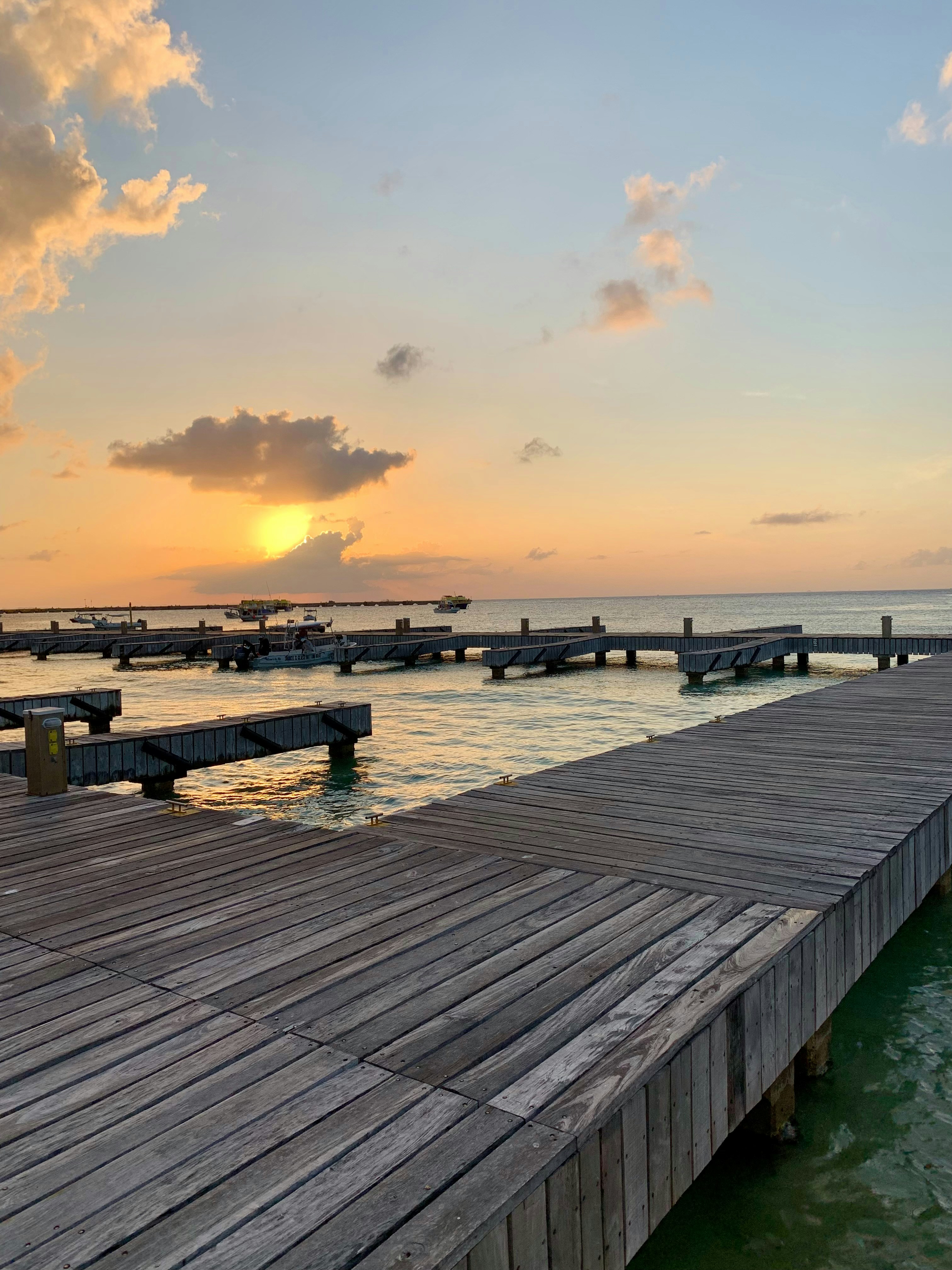 Wooden docks on the ocean at sunset.