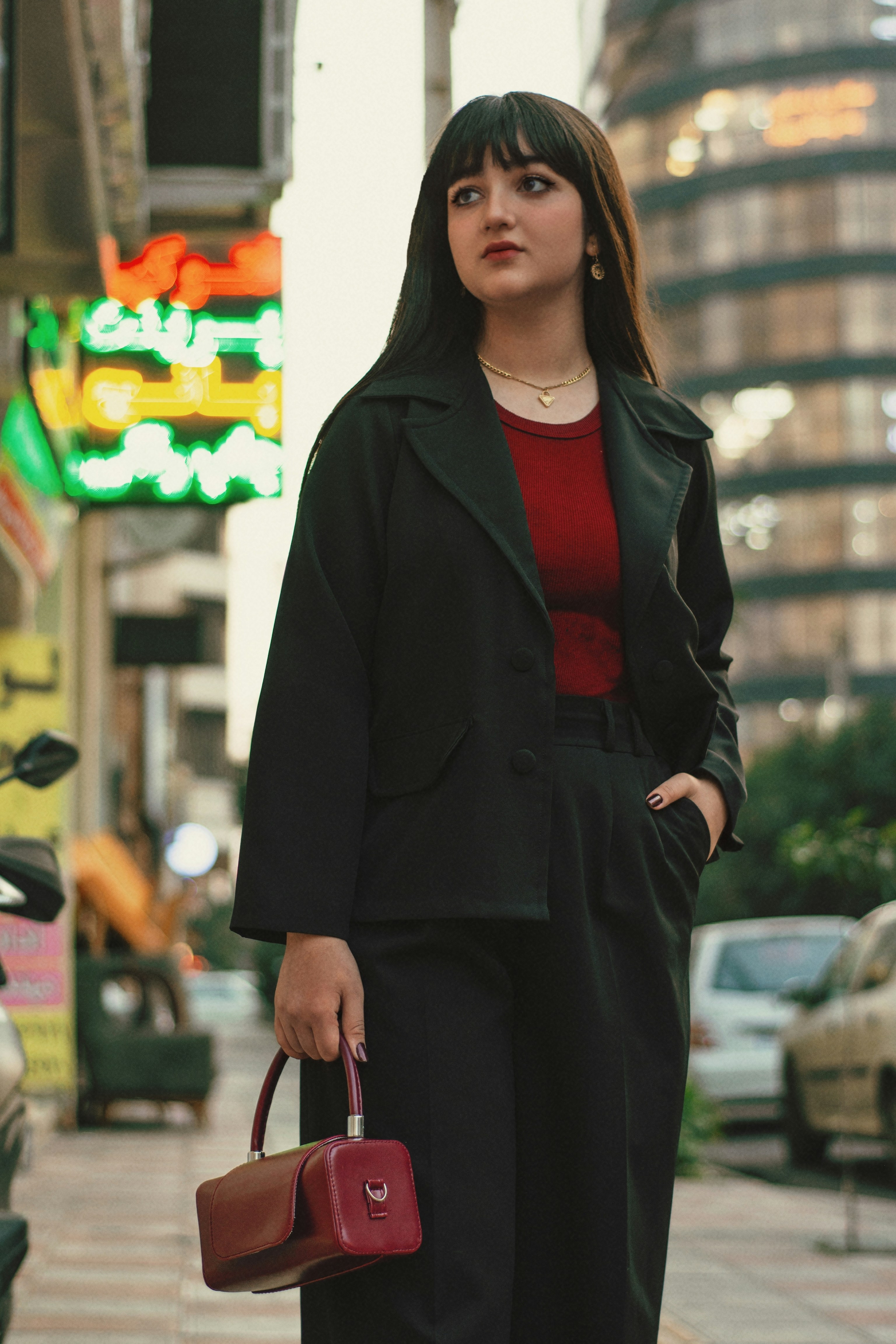 Young woman in black suit holding a handbag