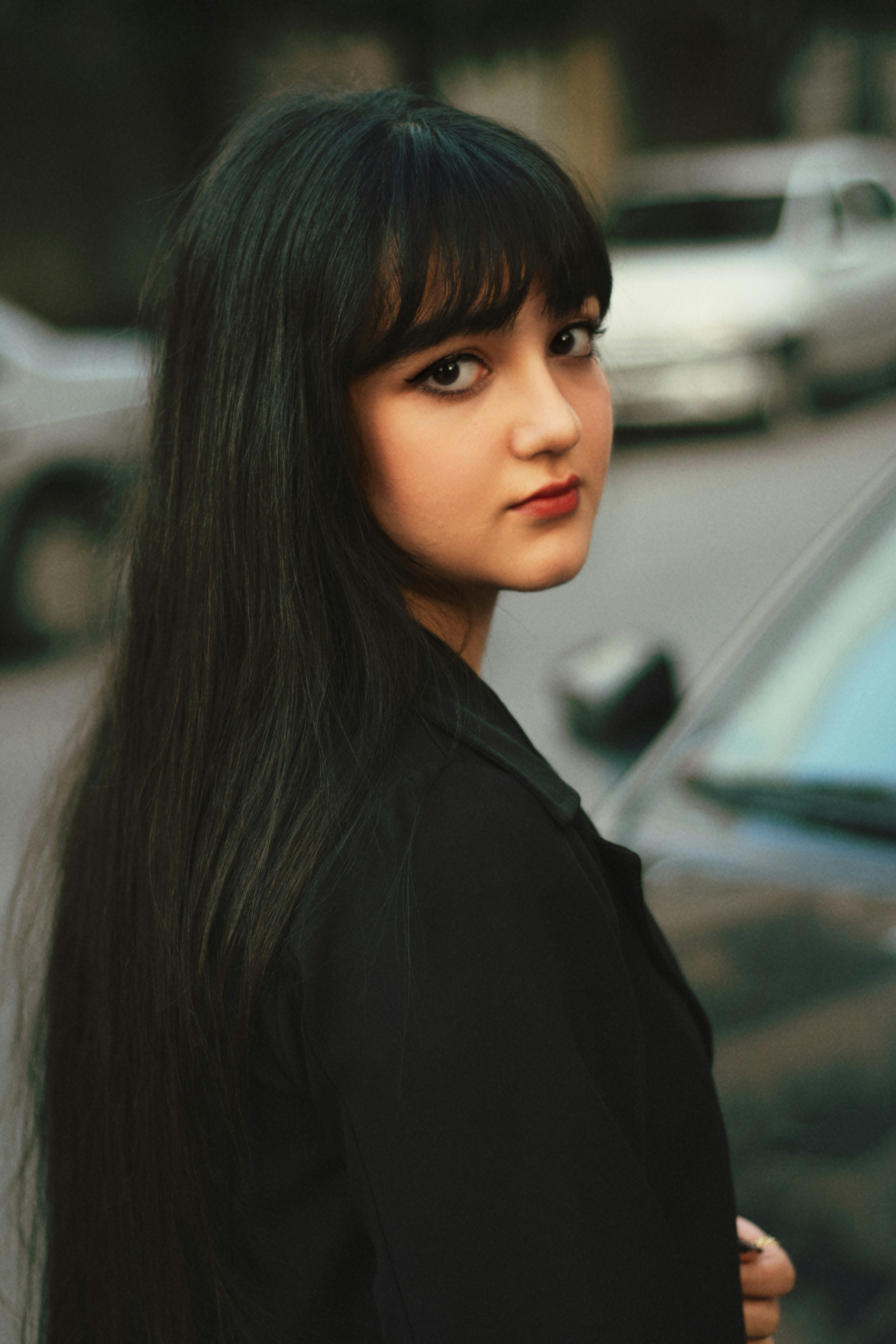 Young woman with long dark hair looking over shoulder