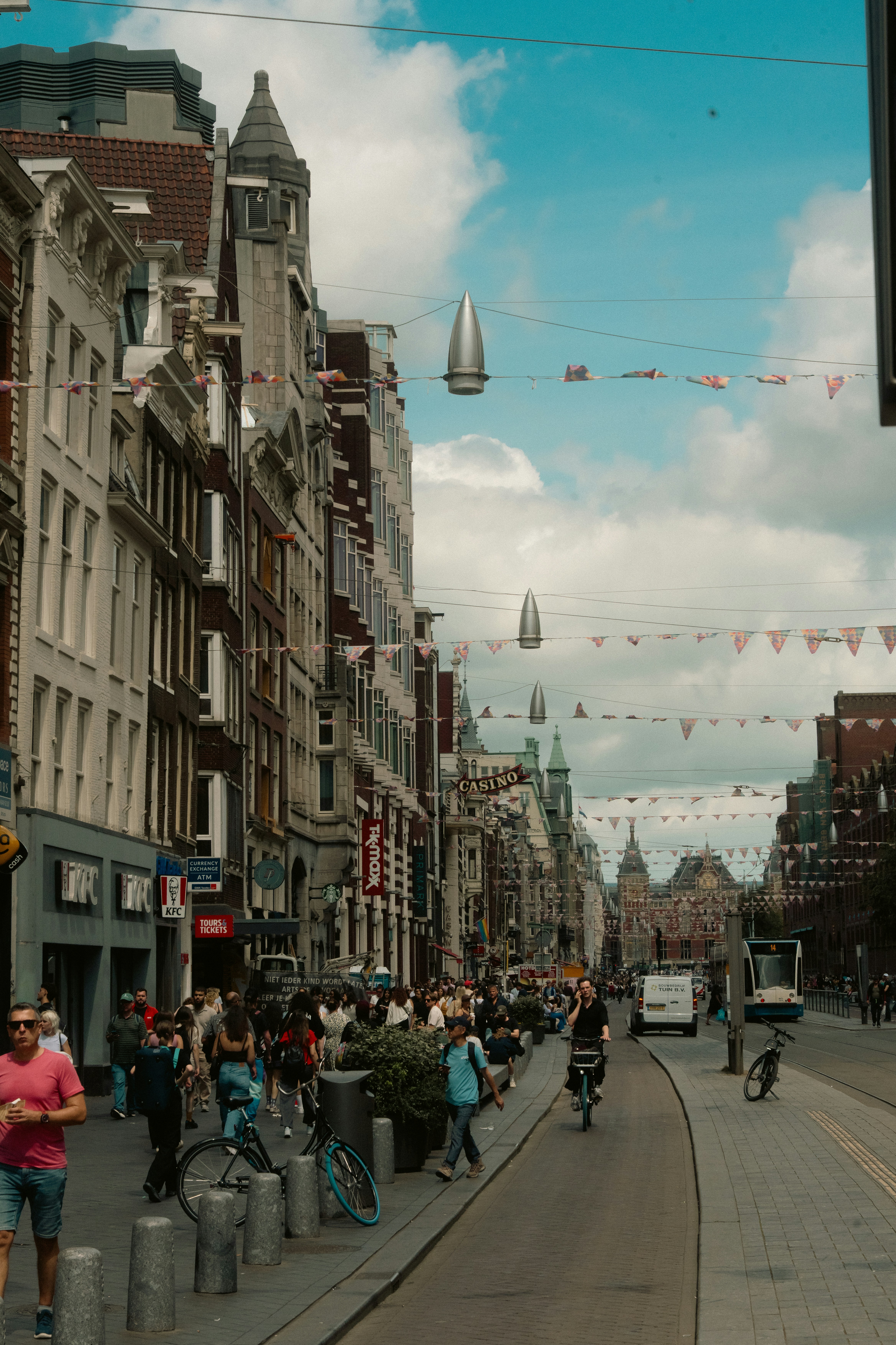 People walking on a busy street with buildings and bicycles.