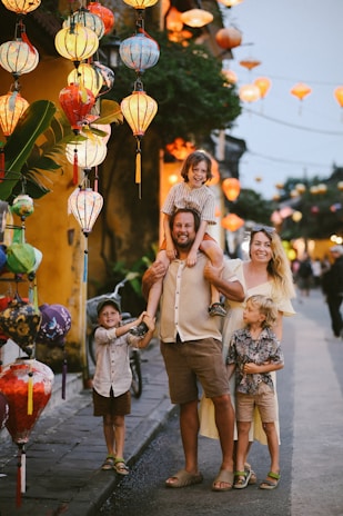 Family posing among colorful lanterns at dusk