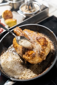 Basting chicken in a hot pan with butter
