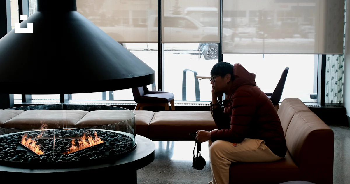 Man sitting by a modern fireplace lounge photo – Free Interior design ...