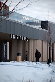 Man walks towards building with "inspire" sign.