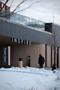 Man walks towards building with "inspire" sign