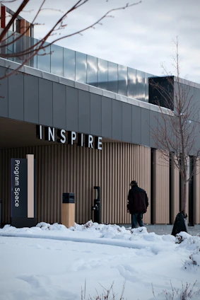 Man walks towards building with "inspire" sign