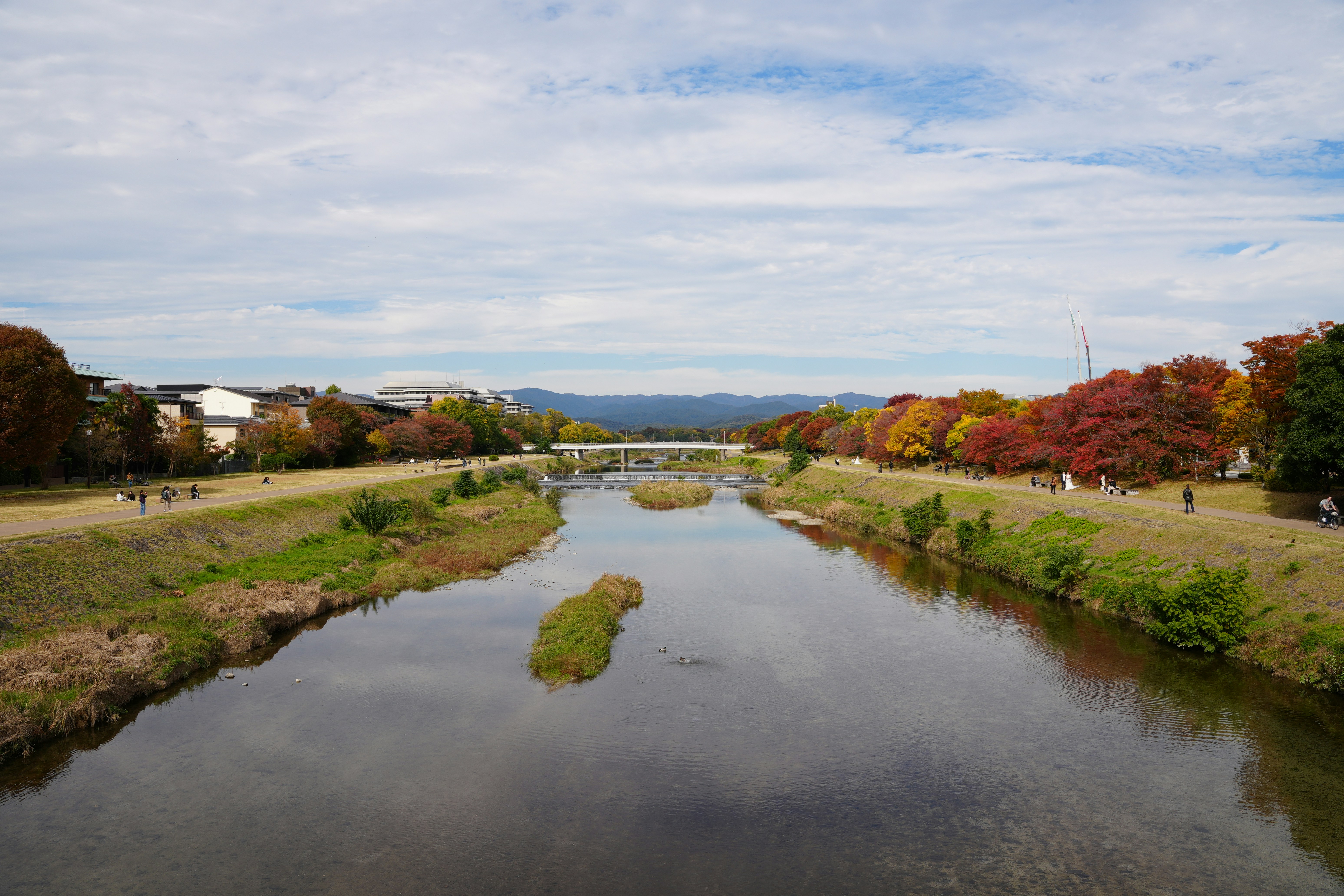 River flowing through a park with autumn trees