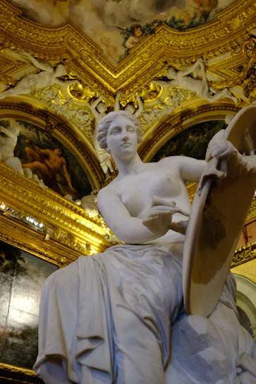Marble statue of venus with ornate golden ceiling