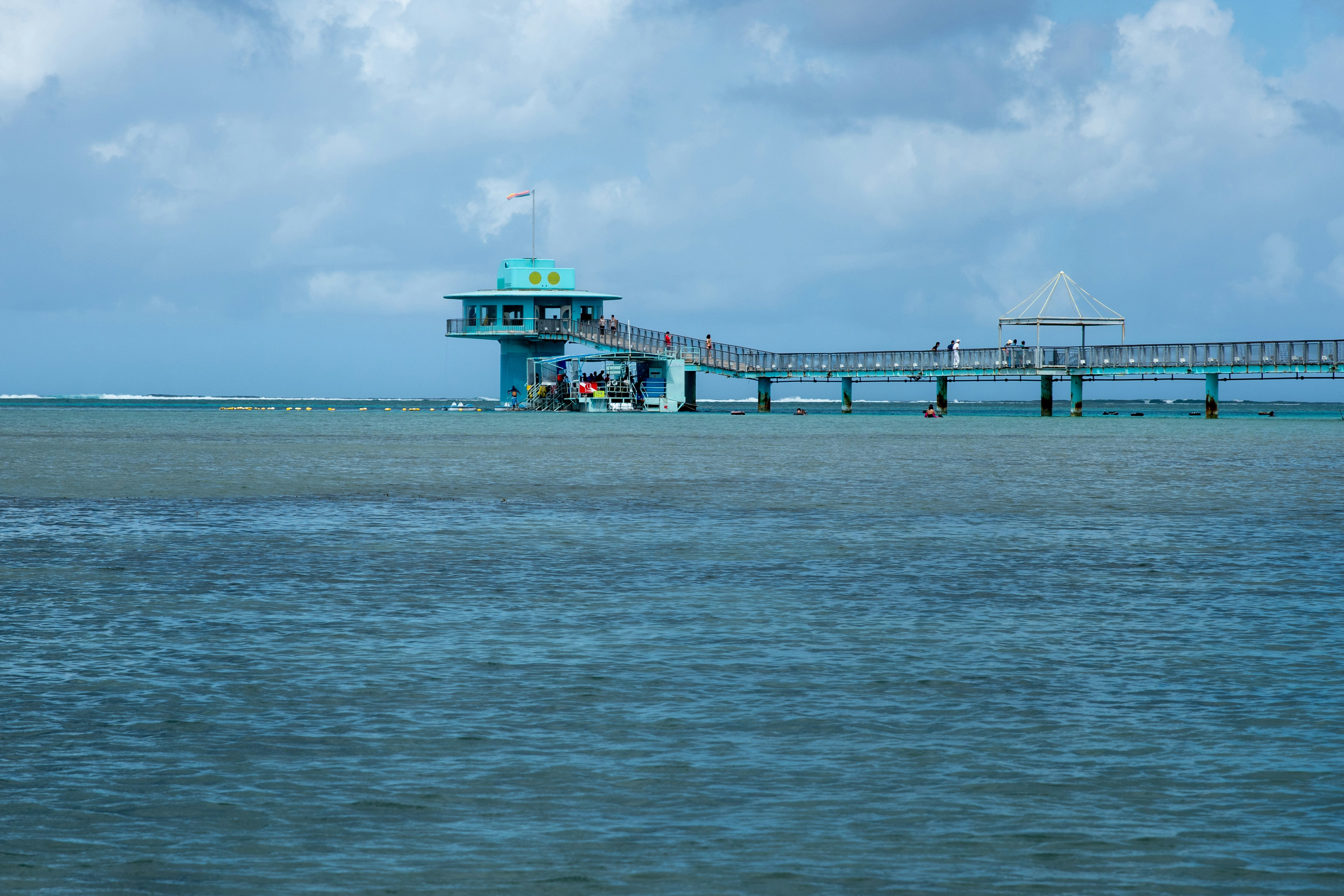 Pier extending over shallow ocean water