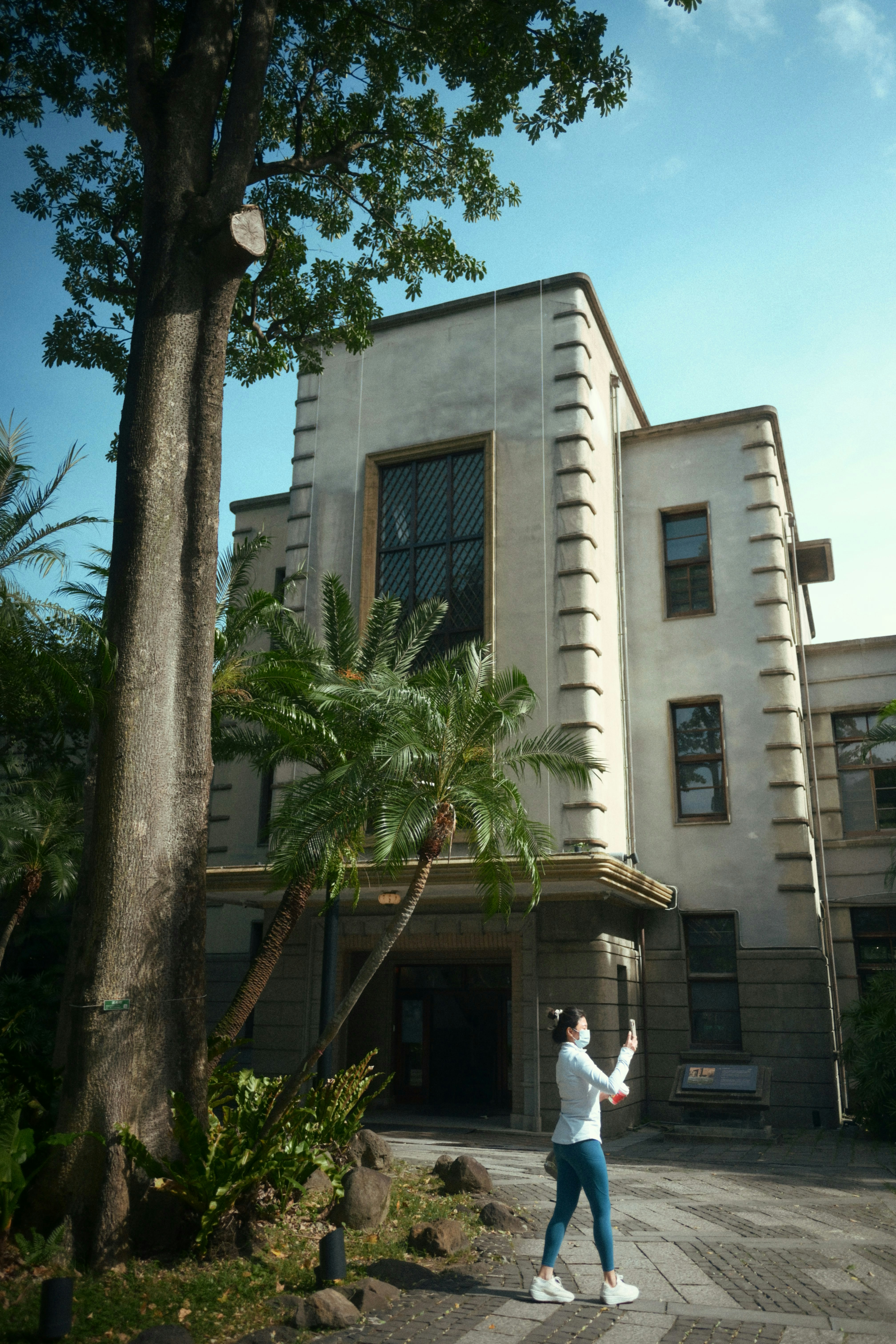 Woman holding phone in front of an old building.