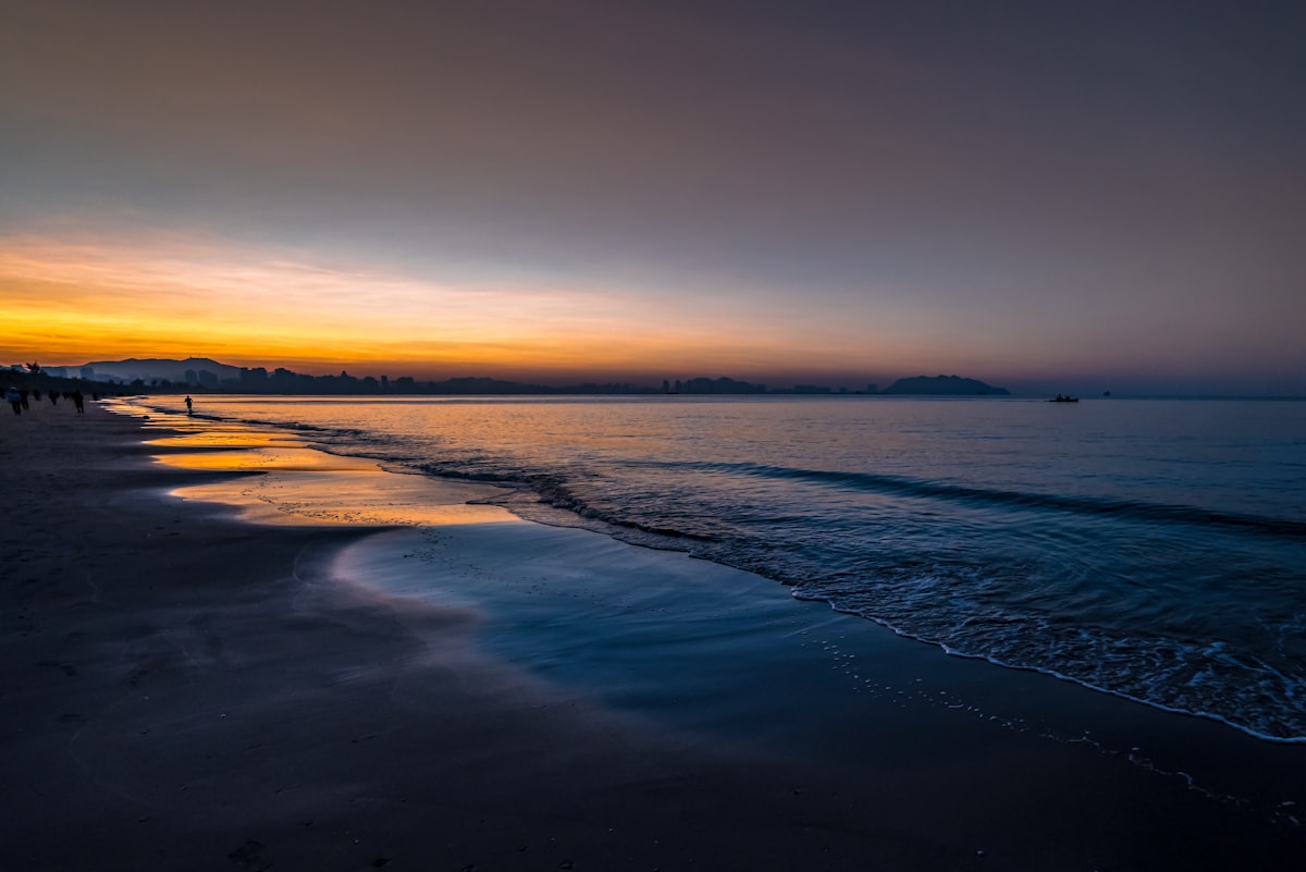 Sunset over a calm ocean and sandy beach