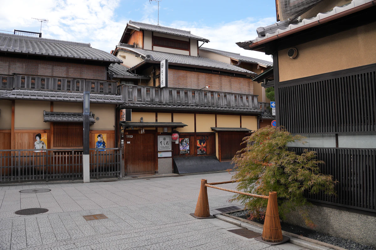 Hanamikoji Street in Gion at dusk, Kyoto — ochaya lanterns lit and the traditional machiya facades stretching south