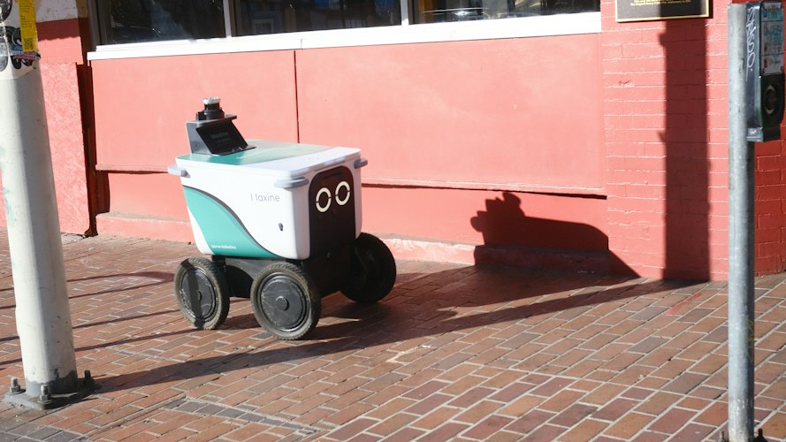 A delivery courier handing a food bag to a customer outside a restaurant