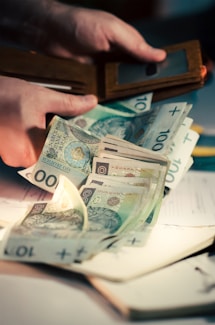 Hands holding polish zloty banknotes from a wallet.