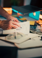 Hands signing a document on a desk.