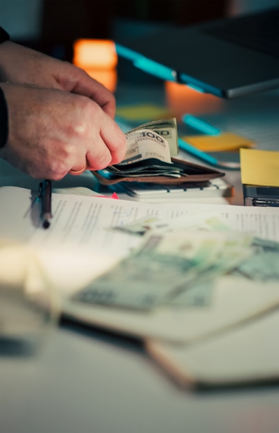 Hands counting money over papers and around papers